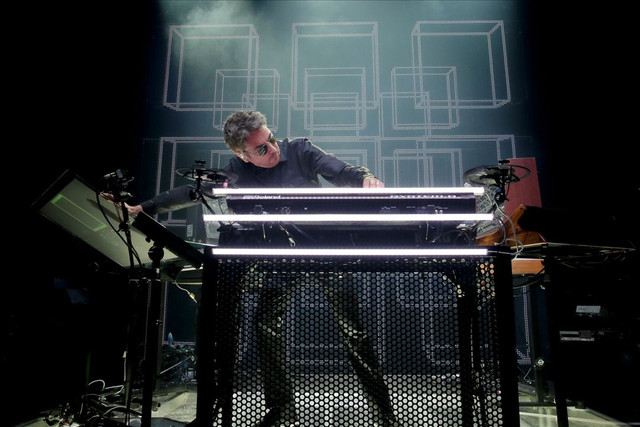 Jean-Michel Jarre performing live on stage with futuristic electronic instruments and modular setup